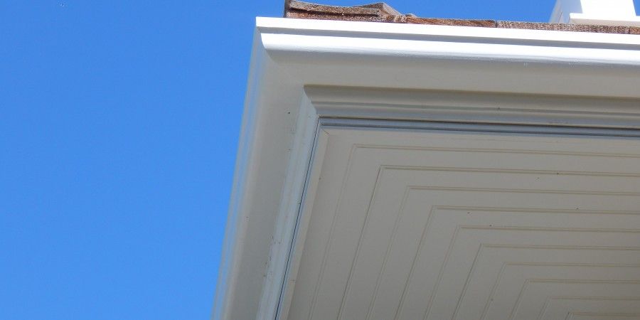 White roof corner against a clear blue sky.