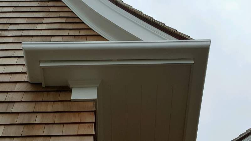 White wooden eaves on a shingle-sided building.