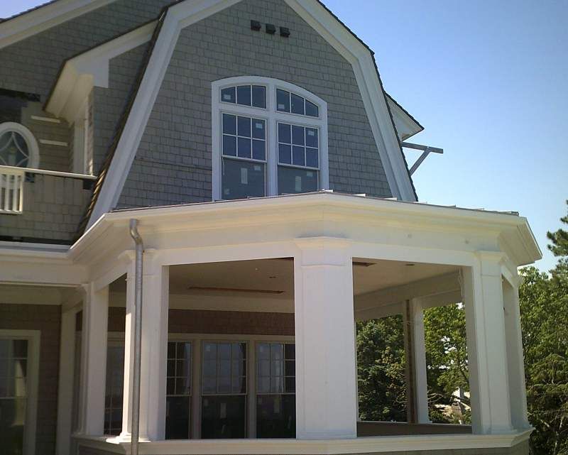 Exterior of a house with gray shingles, white trim, and a porch.