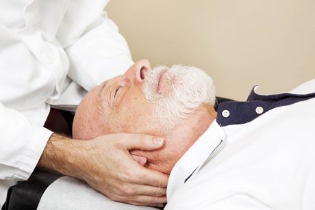 A man with a beard is getting a craniosacral therapy