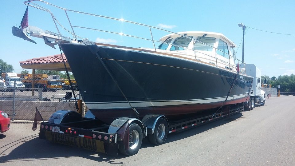 A large boat is being transported on a trailer.