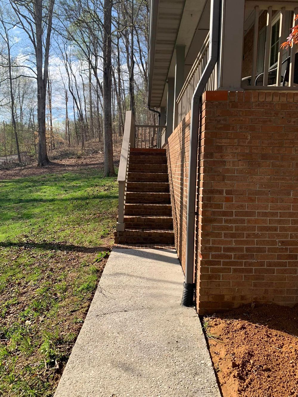 A sidewalk leading to a house with stairs leading up to it