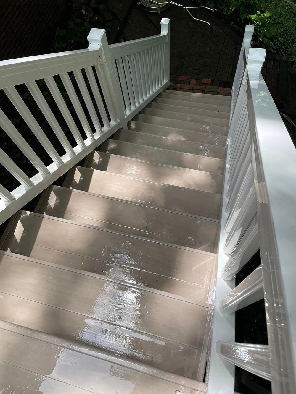 A set of stairs leading up to a deck with a white railing