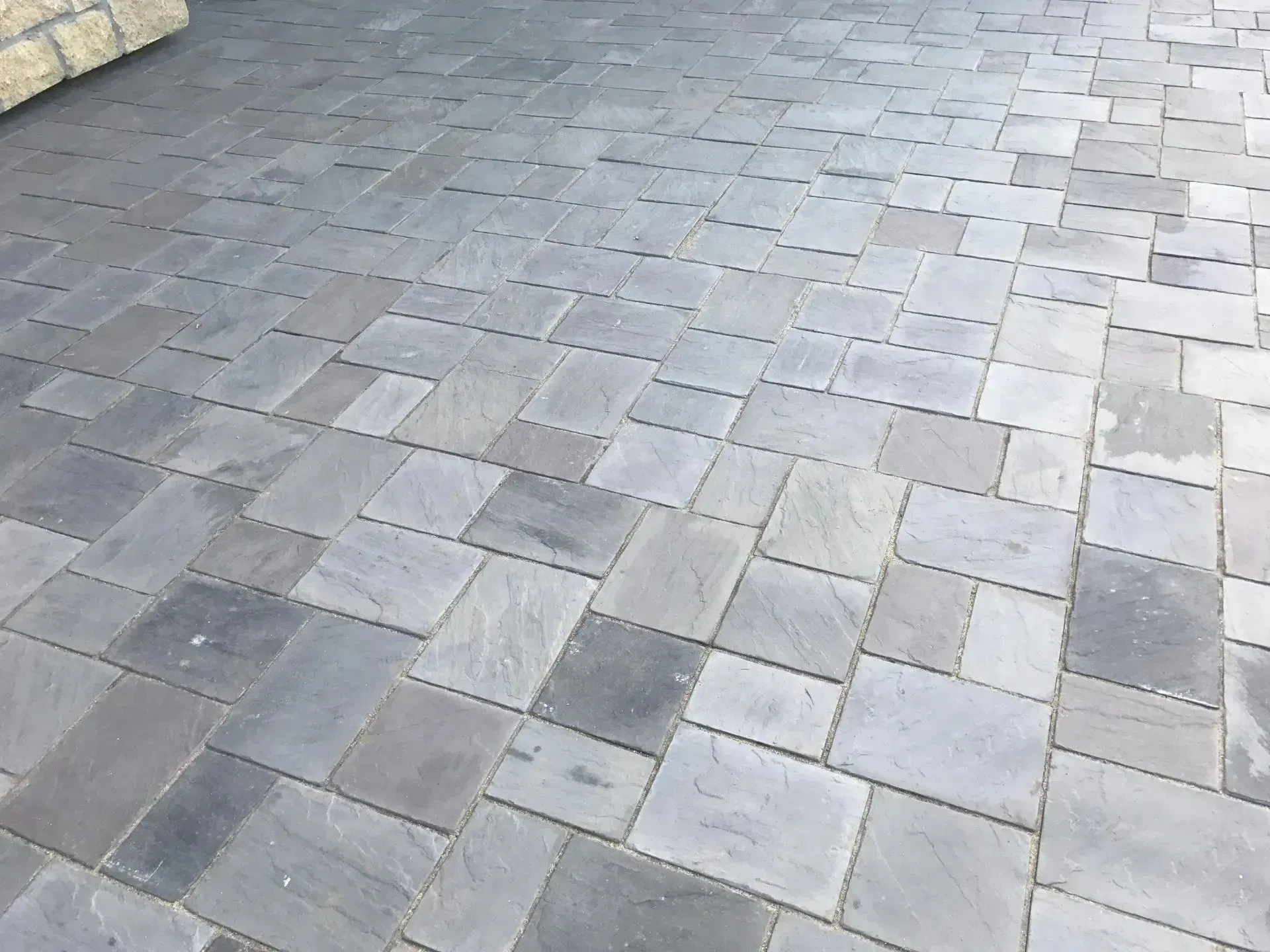 Gray stone pavers in a multi-size, interlocking pattern on a patio surface.
