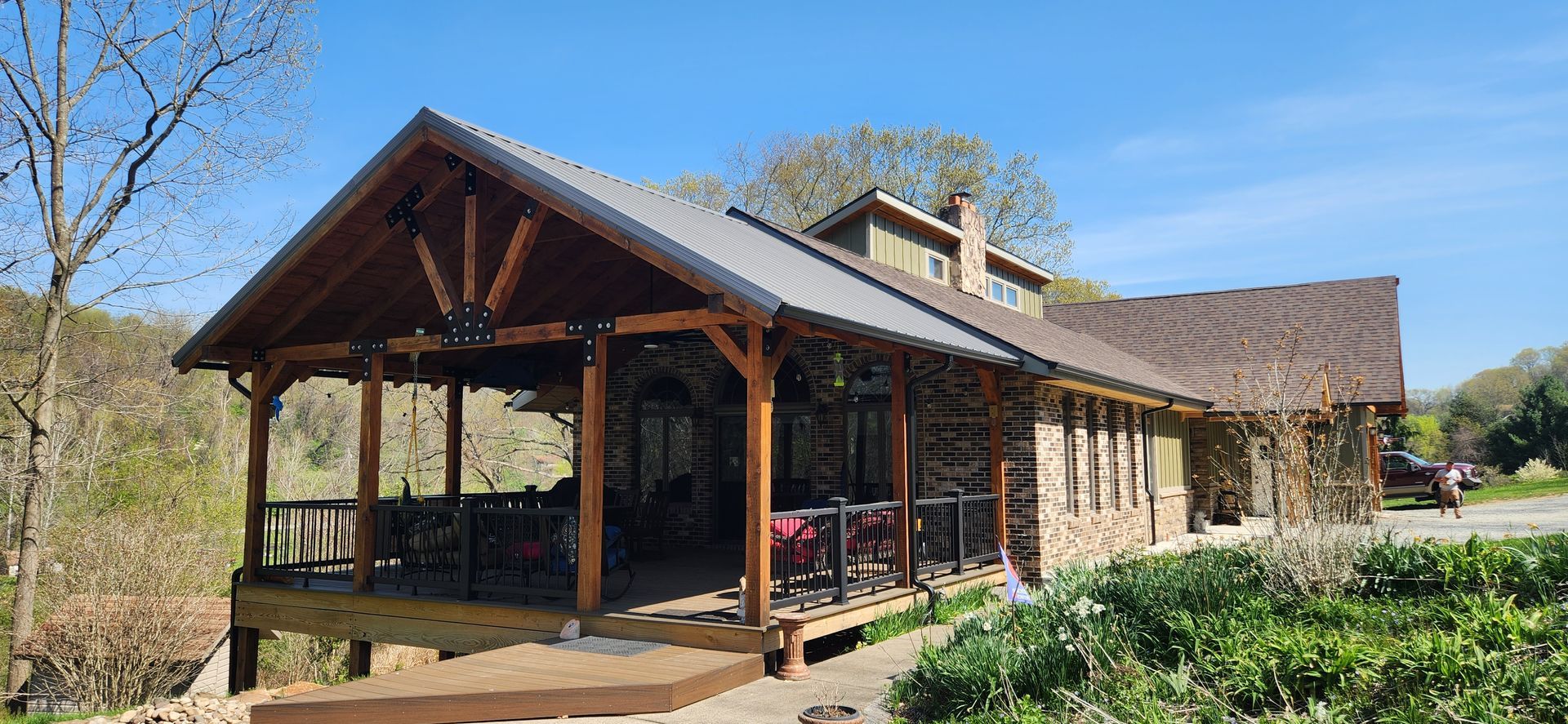 A large wooden house with a porch and a wooden deck.