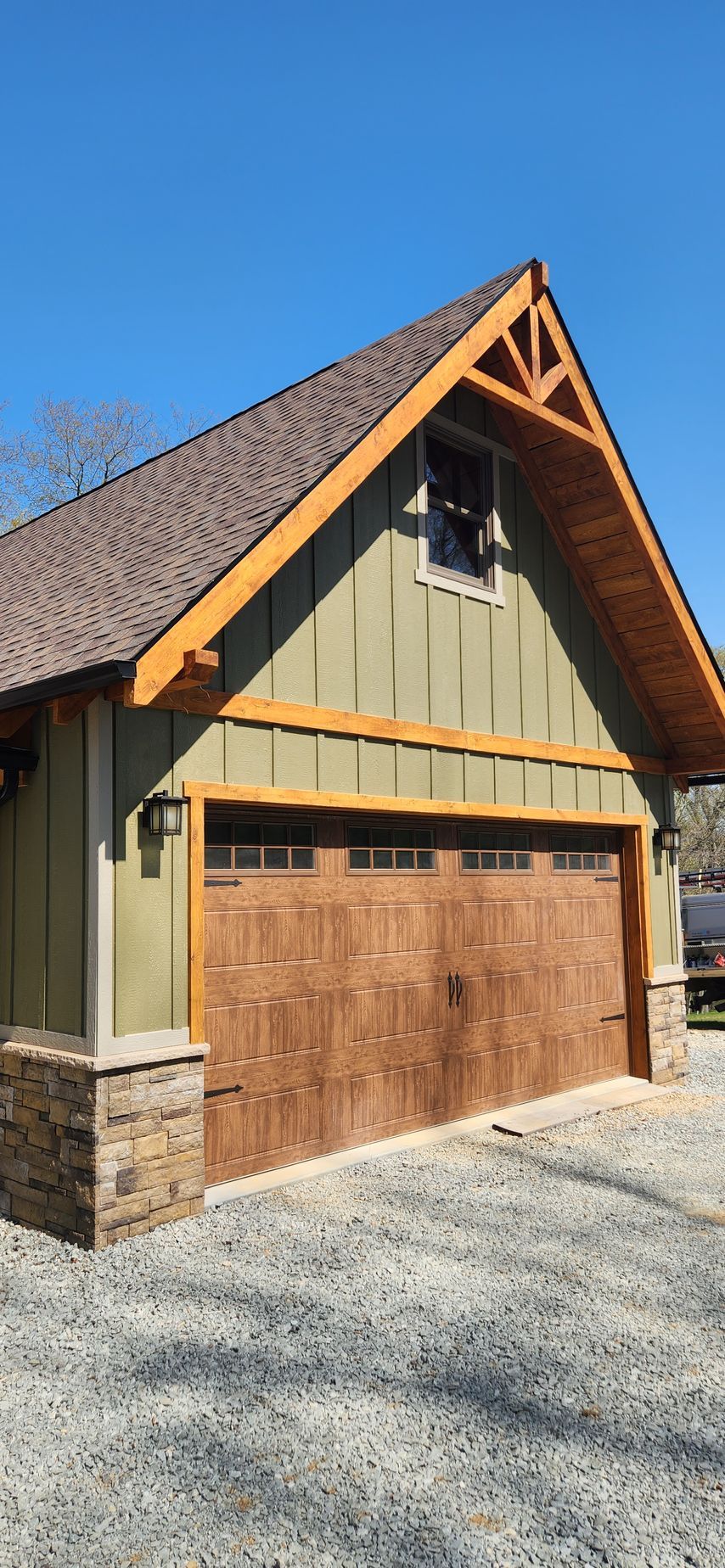 A large garage with a wooden door and a roof.