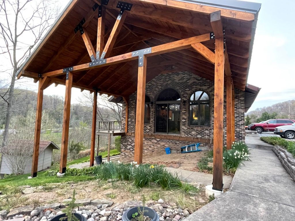 A stone building with a wooden roof and a covered porch.