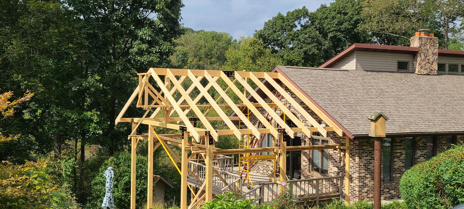 A wooden structure is being built on top of a house.