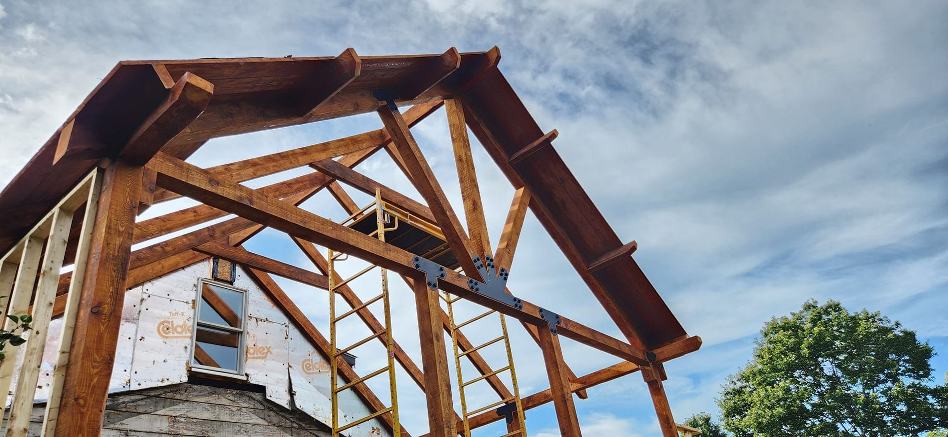 A wooden structure is being built with a blue sky in the background.