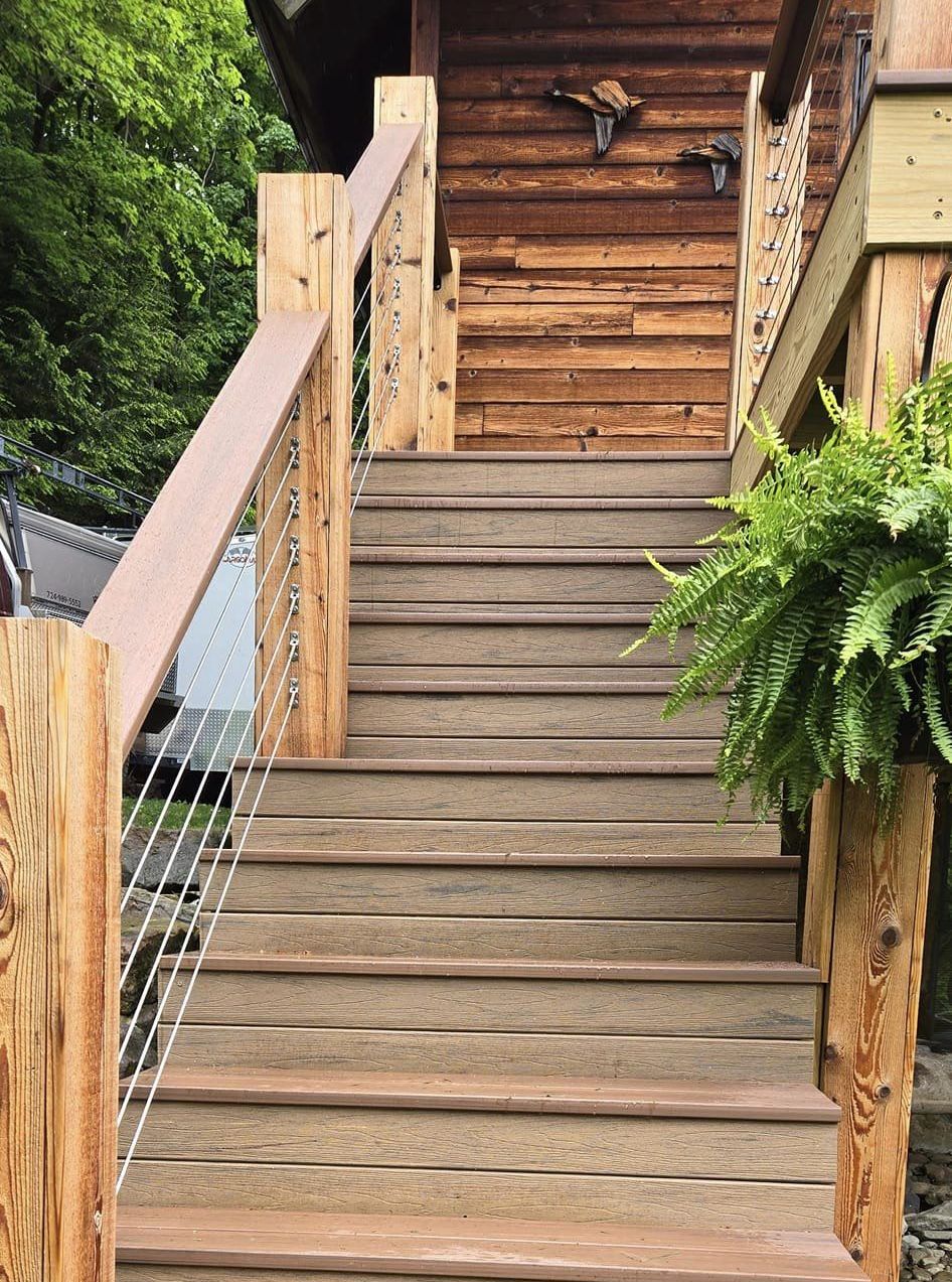 A set of wooden stairs leading up to a wooden house.