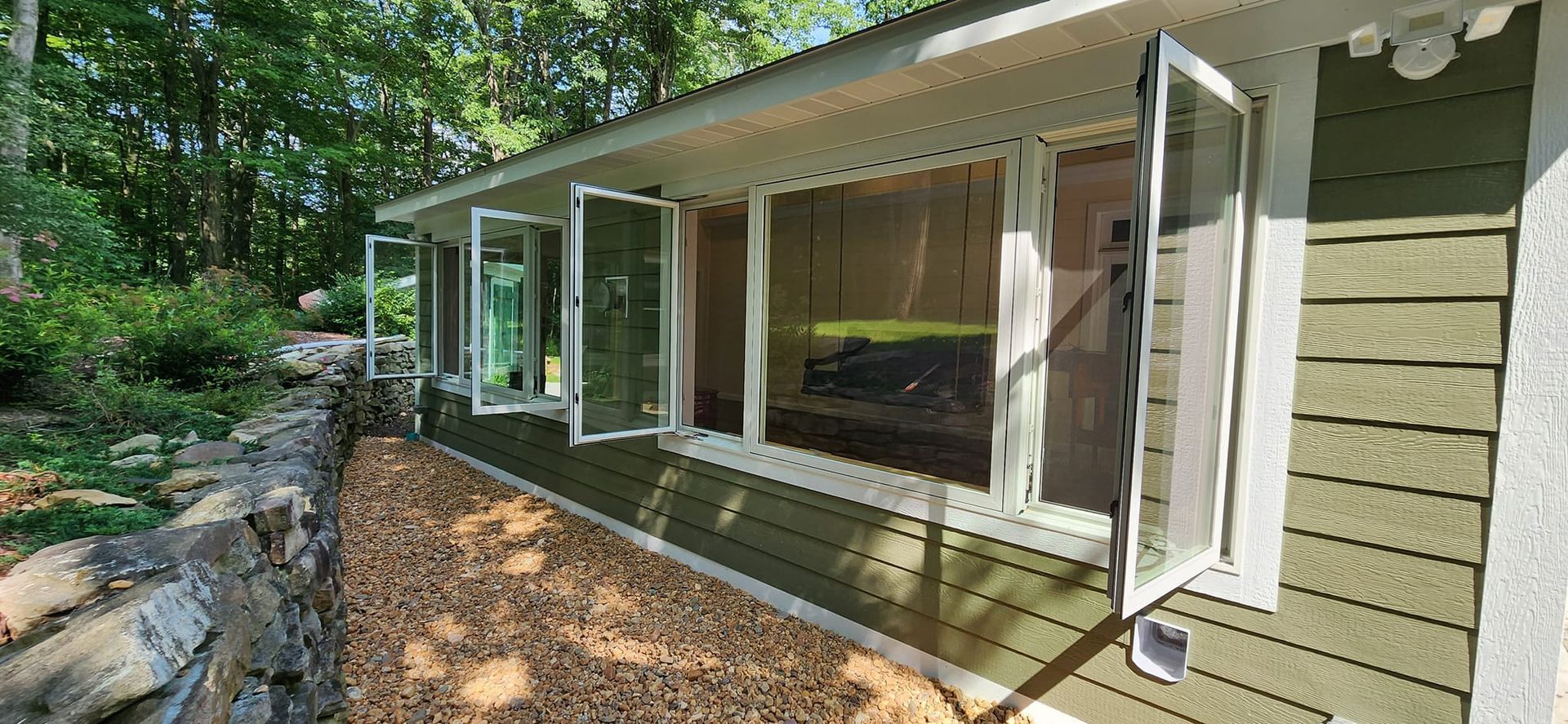 A house with a lot of windows and trees in the background.