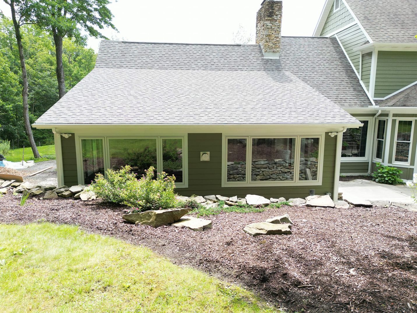 A large house with a lot of windows and a chimney on the roof.