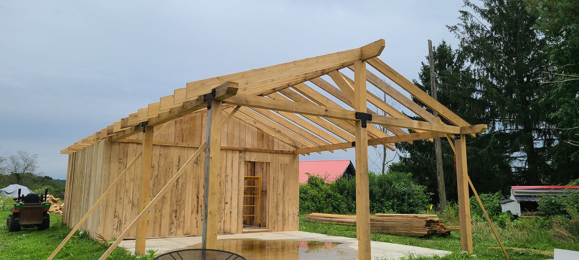 A wooden shed is being built in a grassy field.