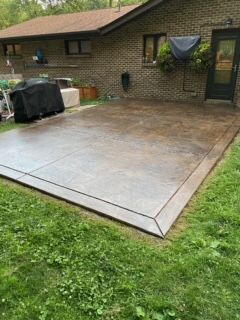 A large concrete patio in front of a brick house.