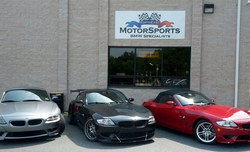 Three BMW Z4 sports cars parked outside a building with a 