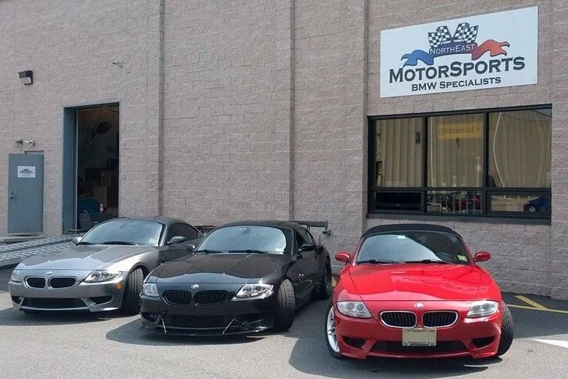 Three BMW Z4 cars parked outside a Motorsports BMW Specialists shop.