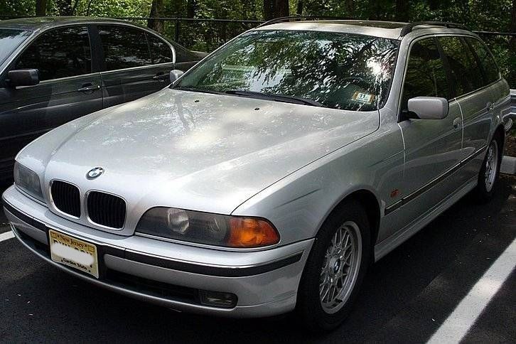 Silver BMW station wagon parked in a lot.