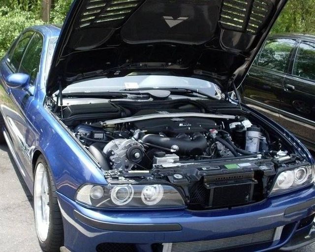Blue BMW car with open hood, showing the engine.