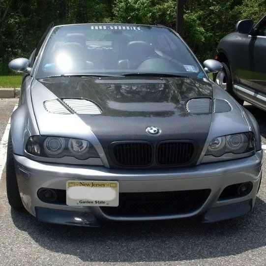 Silver BMW M3 with carbon fiber hood, in a parking lot.