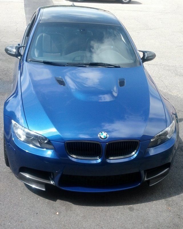 Blue BMW M3 coupe parked on asphalt. Black roof and trim, daytime.