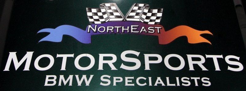 Northeast Motorsports sign with checkered flags and a ribbon design; 