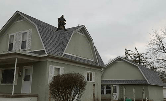 A house with a roof that has a chimney on top of it.