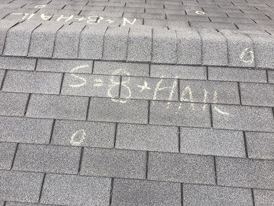 A close up of a roof with chalk written on it.