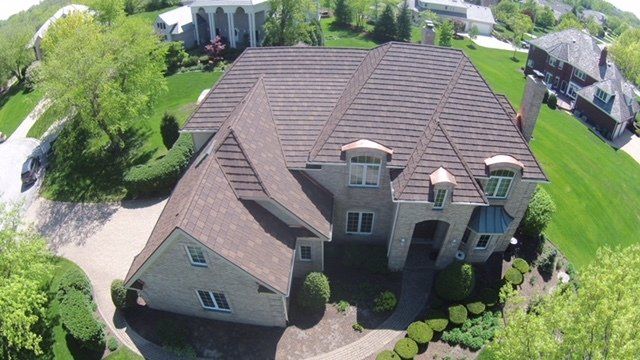 An aerial view of a large house with a brown roof