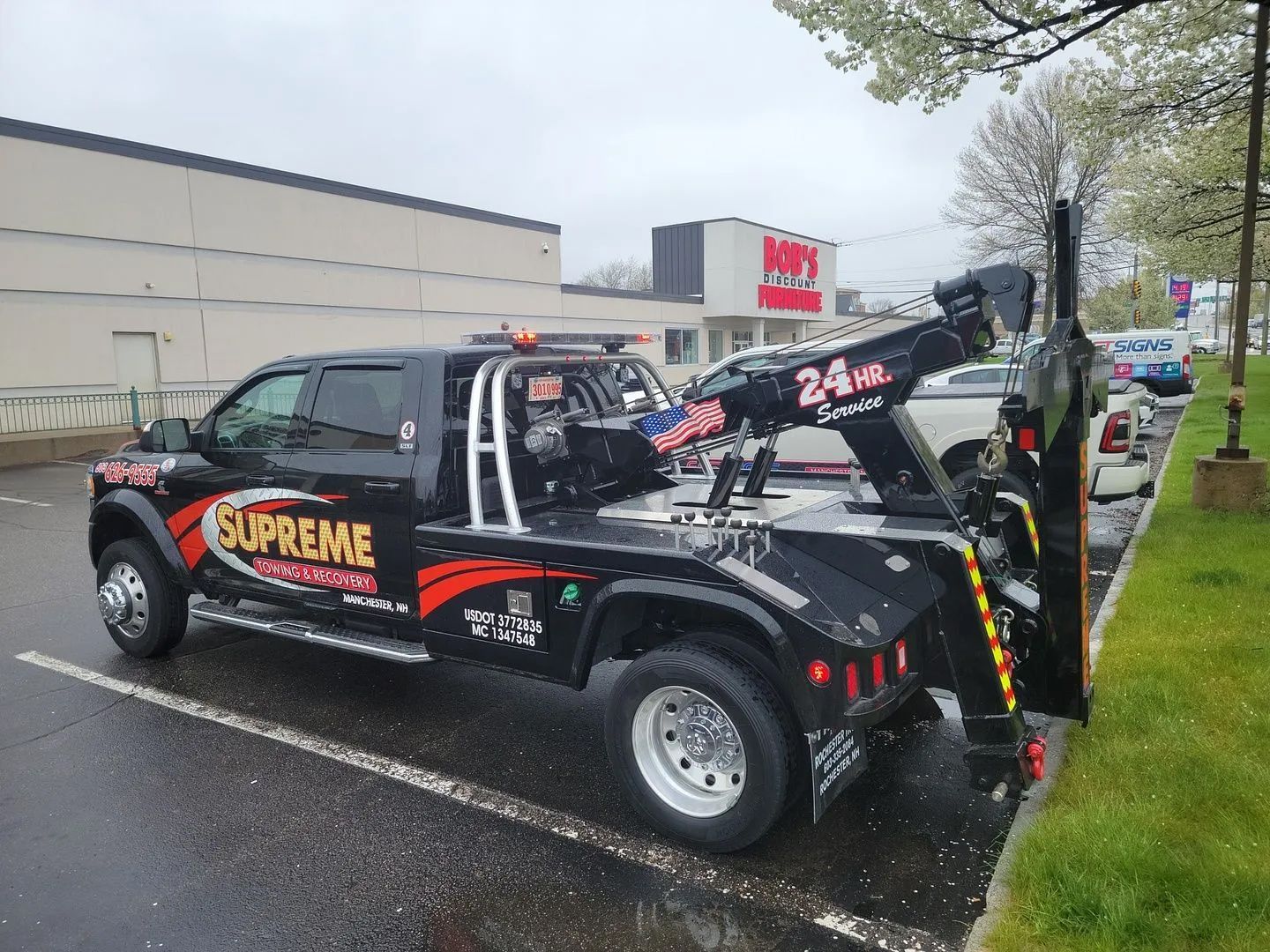 A supreme tow truck is parked in a parking lot.