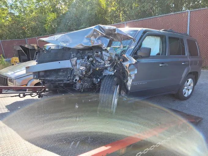 A wrecked jeep is sitting on the side of the road.