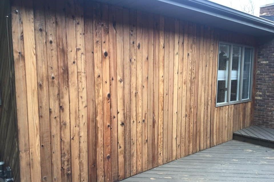 A house with a wooden siding and a wooden deck.