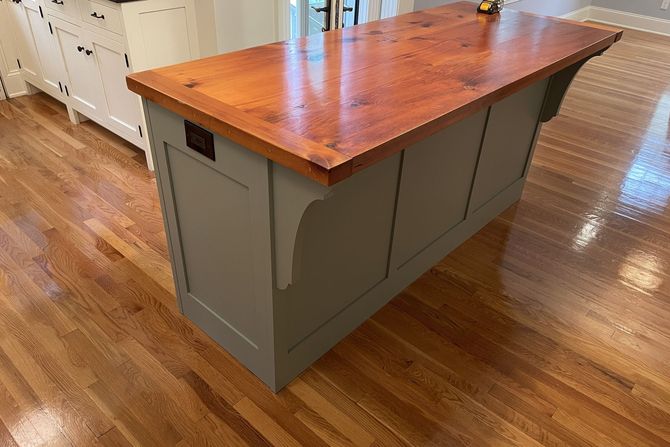 A kitchen island with a wooden top and hardwood floors.