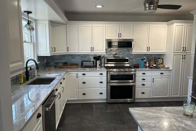A kitchen with white cabinets and stainless steel appliances.