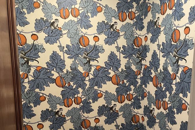 A wall with a pattern of leaves and pumpkins on it