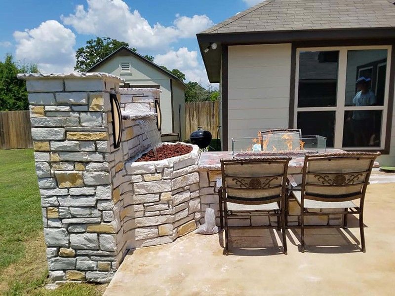 A patio with a table and chairs in front of a house.
