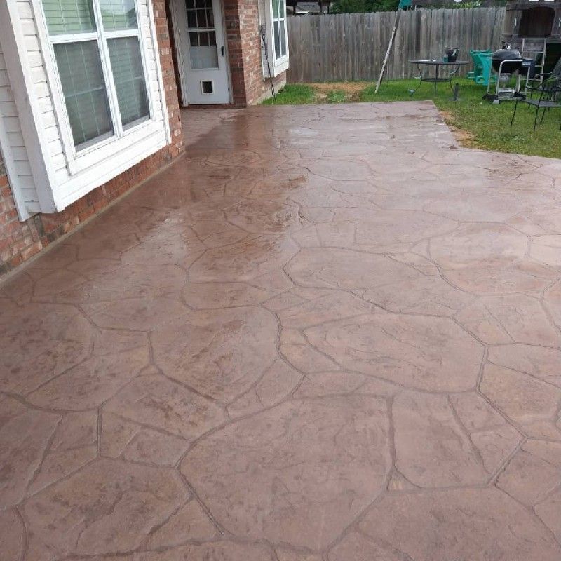 A brick house with a concrete patio in front of it