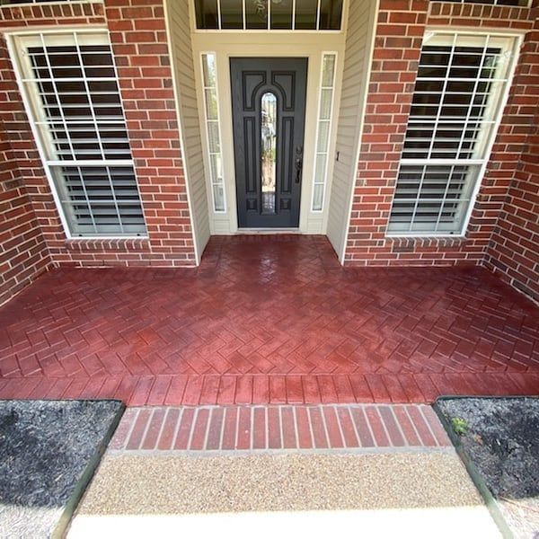 A brick house with a red porch and a black door