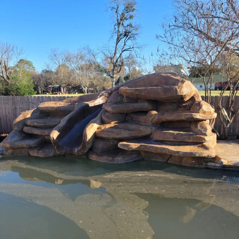 A large rock formation with a slide in the middle of it