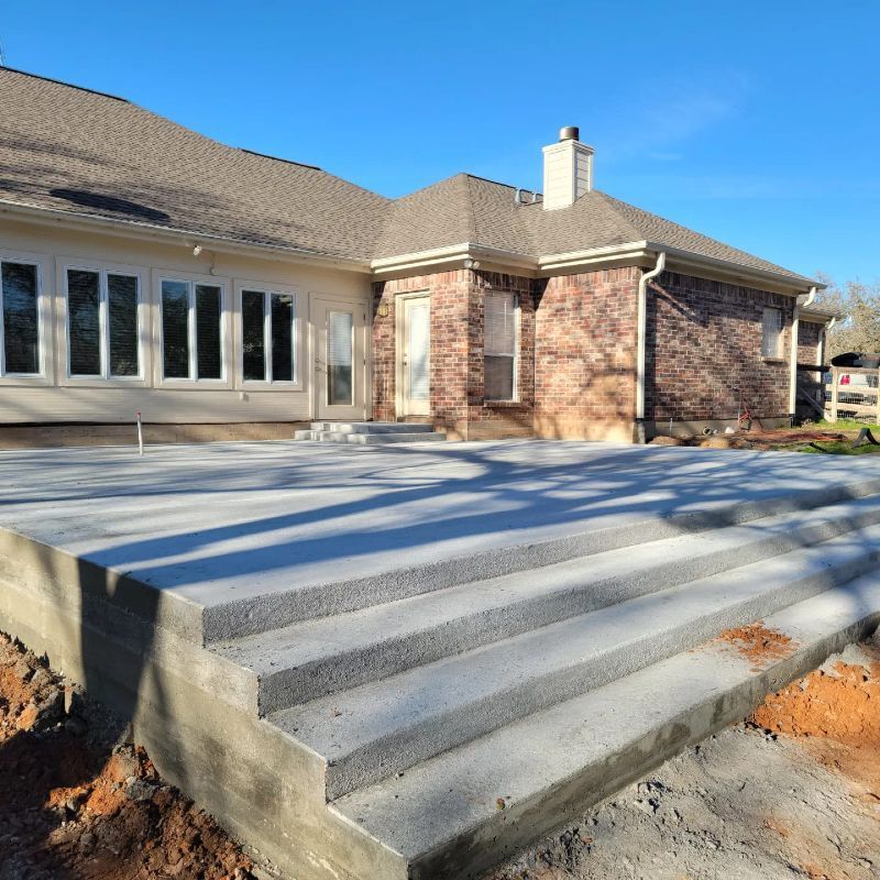 A brick house with a concrete deck in front of it