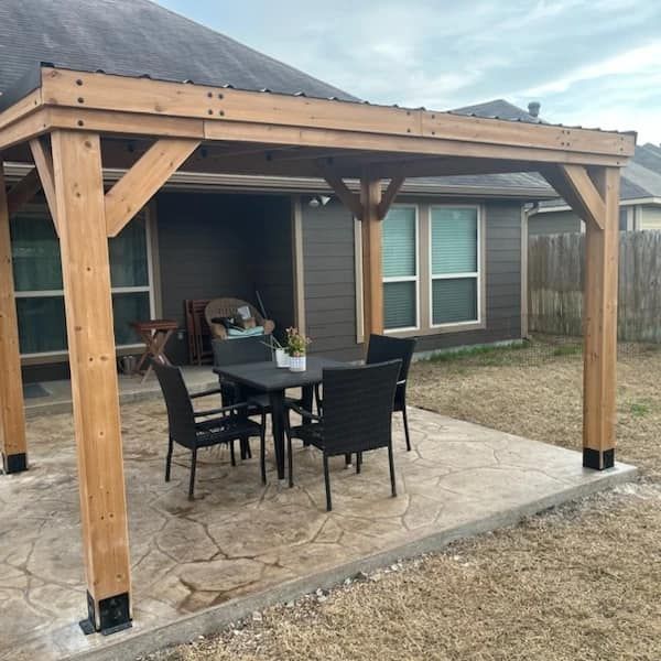 A wooden pergola with a table and chairs underneath it