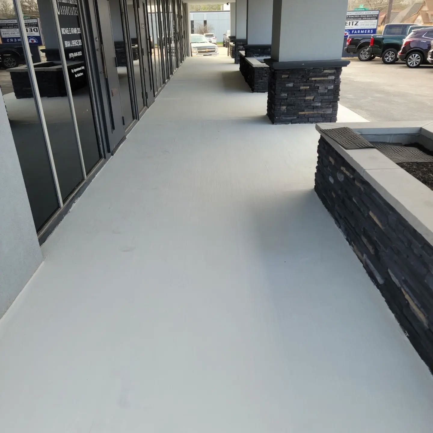 A hallway with a white floor and a brick wall