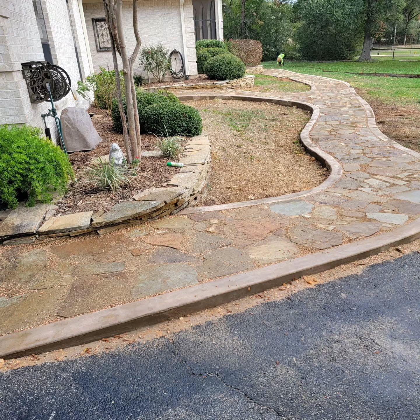 A stone walkway is being built in front of a house.