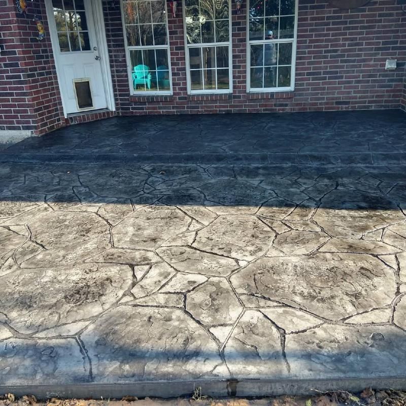 A brick house with a concrete patio in front of it.