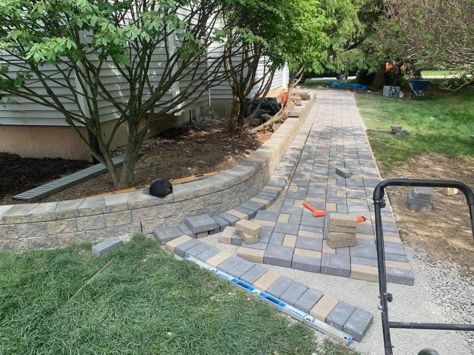 A walkway is being built in the backyard of a house.