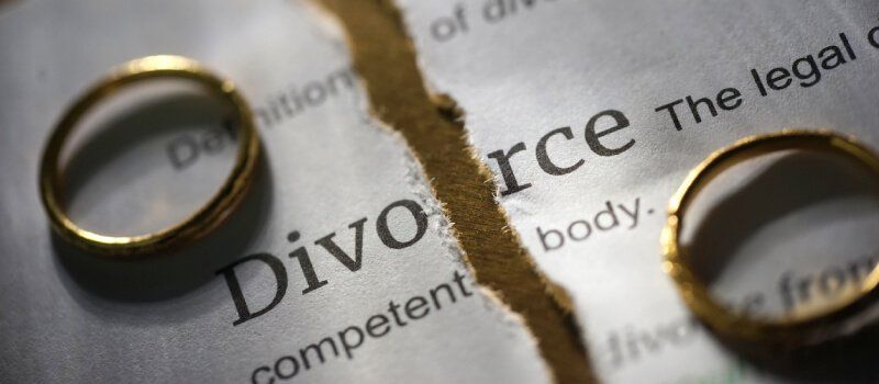 Divorce paper with wedding bands