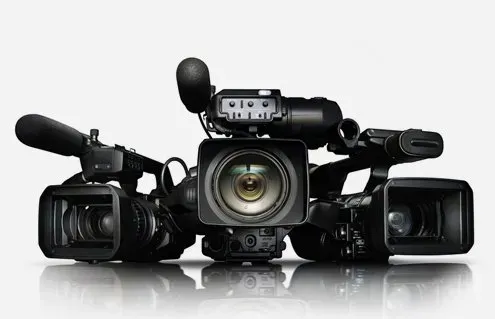 A bald man wearing glasses and a suit is smiling for the camera.