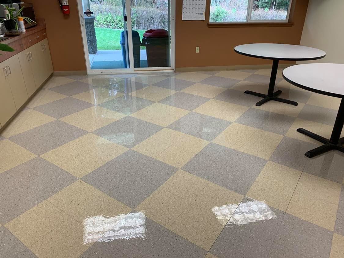 Checkerboard-patterned floor in a room with two tables, a sliding glass door, and tan walls.