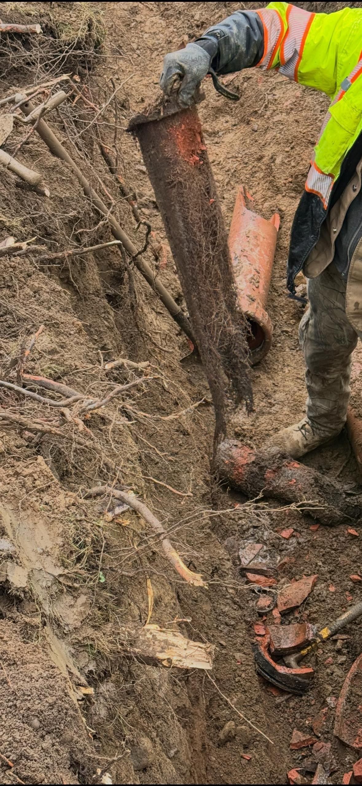 A construction worker is digging in the dirt with a shovel.