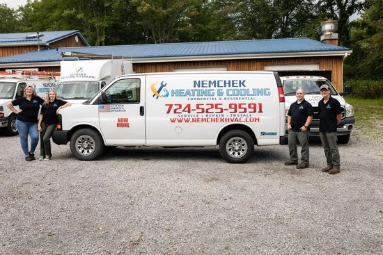 White service van with company logo and phone number, parked outside a building with four workers standing beside it.