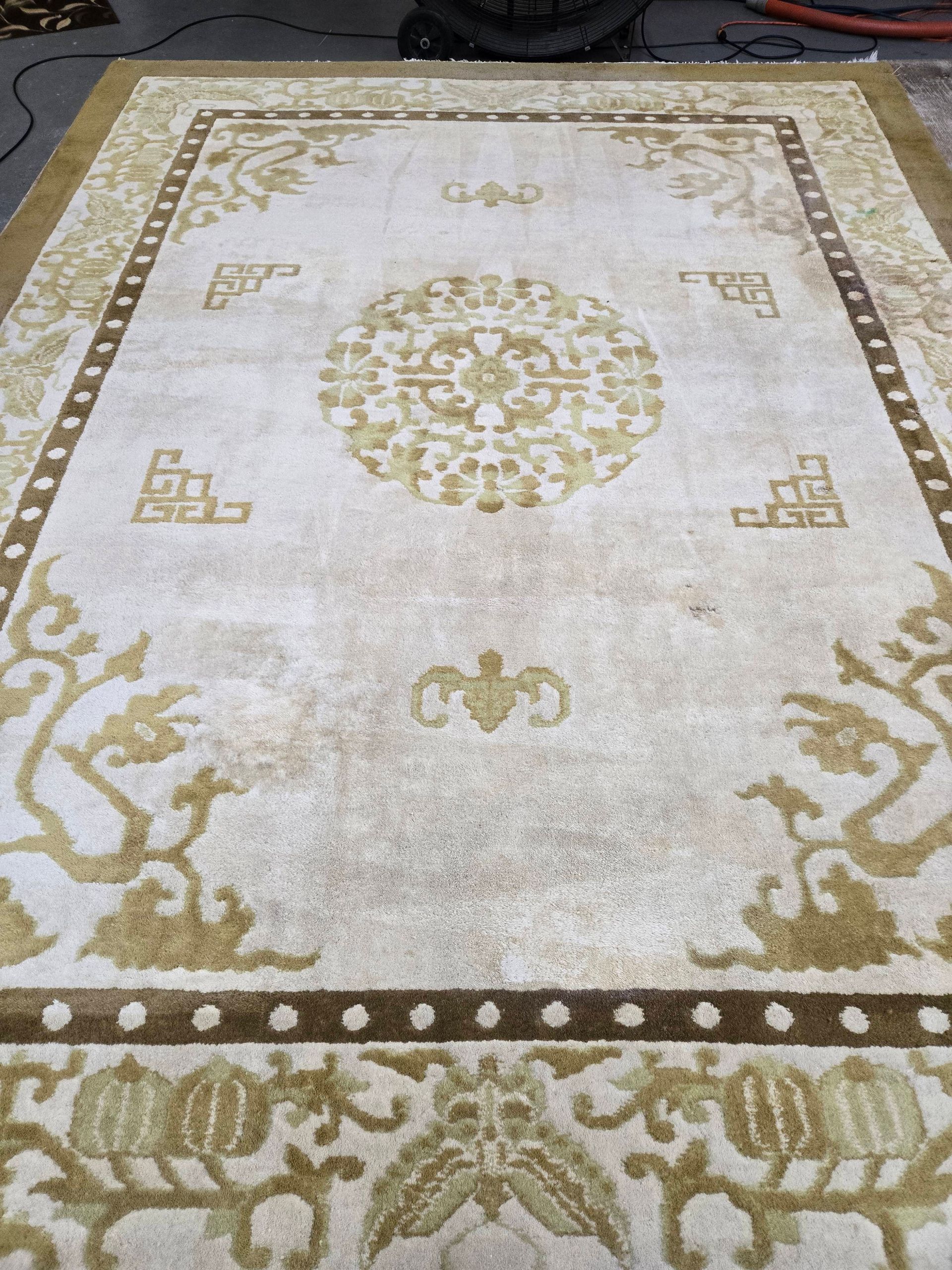 Cream and gold rug with ornate floral and geometric patterns.